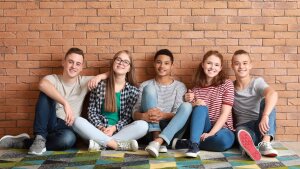 Teenager sitzen vor einen gemauerten Wand